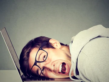 Man frustrated at computer laying his head on the keyboard